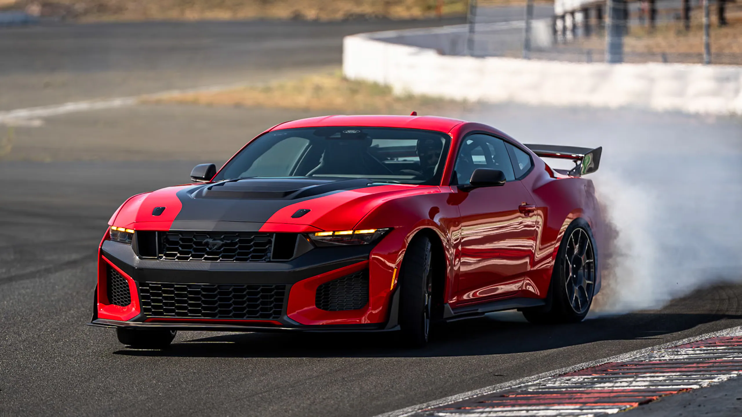 Red sports car drifting on a racetrack, creating smoke from the tires.